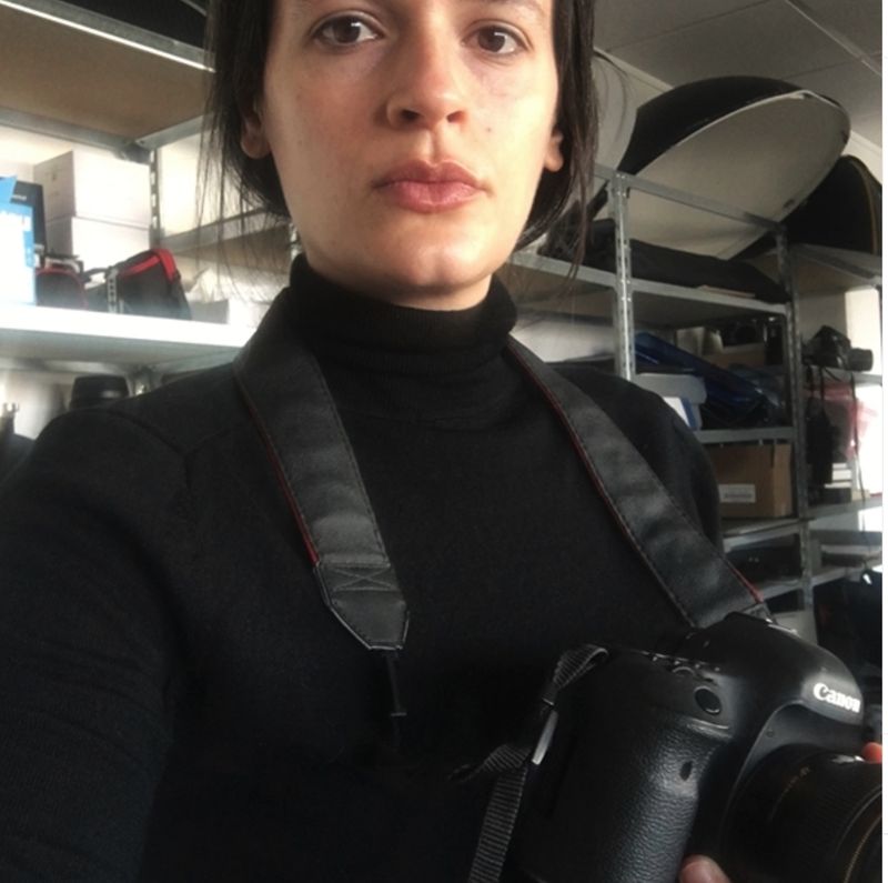 Alice in a black polo neck with a camera around her neck